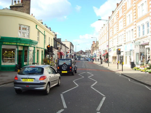 Archive view along Wimbledon Village High Street showing traditional shopfronts and period buildings